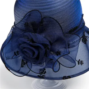 Detail of navy blue organza flower with black rose prints on an elegant sun hat