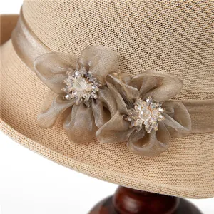 Détail de fleurs en tissu faites main avec perles de cristal sur un chapeau de paille
