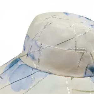 Detail of sun hat fabric with blue floral print and silver metallic stitching texture