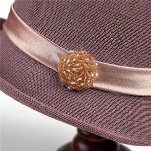 Detail of lavender woven sun hat featuring a champagne ribbon and crystal flower ornament