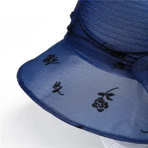 Detail of navy blue organza sun hat with black rose floral pattern and pleated texture