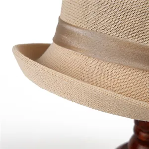Détail de chapeau de paille tressé avec texture fine et ruban en satin marron