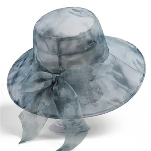 Detail of elegant sun hat showing sheer organza fabric and blue tie-dye floral pattern