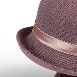 Detailed macro view of purple woven sun hat with a silky champagne gold decorative ribbon