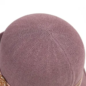Close-up of the fine woven texture and decorative rhinestone strap on the mauve sun hat