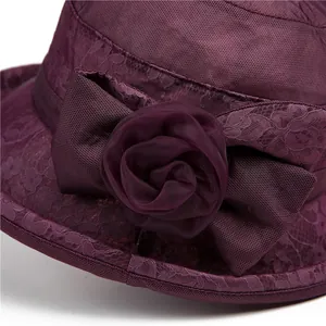 Detailed view of dark purple lace sun hat featuring a handcrafted fabric rose and mesh bow