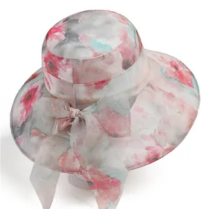 Close-up of wide-brim floral sun hat with light watercolor print and bow detail