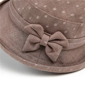 Detail of a brown sun hat featuring floral prints, side bow, and fine zigzag stitching