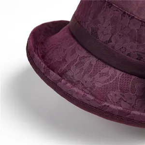 Detailed close-up of dark purple lace sun hat with floral embroidery and satin ribbon