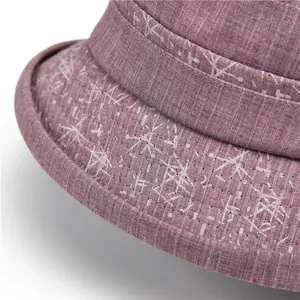 Close-up of pink cotton fabric with floral prints and reinforced stitching on sun hat brim