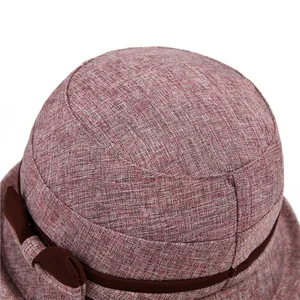 Detailed close-up of breathable rose pink fabric sun hat with brown bow decoration