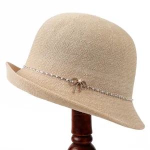Eleganter beiger Strohhut mit Strass-Schmetterling und Perlenbesatz für den Sonnenschutz