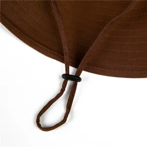 Detailed view of the dark brown sun hat with adjustable drawstring and plastic toggle