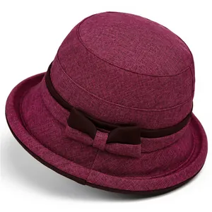 Close-up of deep pink sun hat featuring woven texture and a brown decorative bow