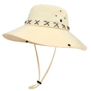 Detail of cream wide-brim cowboy hat with leather cross-stitch band and wind cord