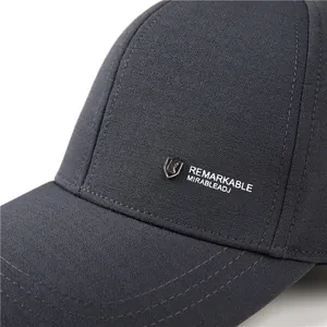 Gorra de béisbol gris oscuro con textura de rejilla y detalle de logo de escudo metálico