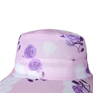 Detailed view of pink mesh sun hat fabric with purple rose floral patterns and stitching