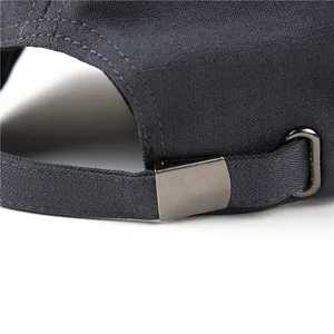 Detalle de la hebilla metálica ajustable y tejido gris texturizado en una gorra militar