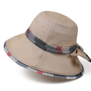 Detail of elegant khaki sun hat featuring a classic plaid ribbon and bow decoration