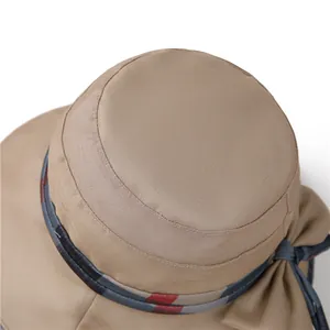 Detailed close-up of khaki sun hat with plaid ribbon trim and decorative side bow