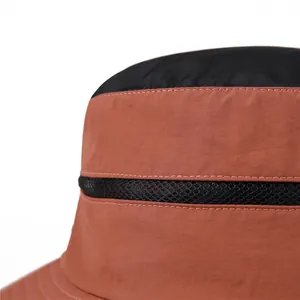 Detail view of brick red and black outdoor sun hat featuring breathable mesh and neat stitching