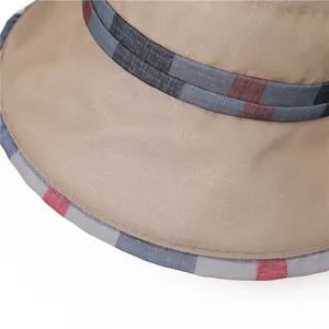 Detail of khaki sun hat featuring textured fabric and classic colorful plaid ribbon trim