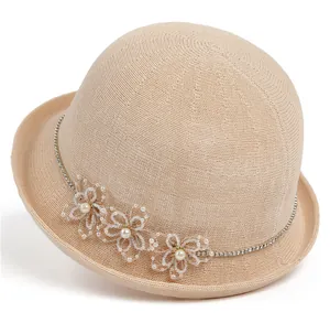 Détail du tissage de chapeau beige avec fleurs en perles et bordure en strass