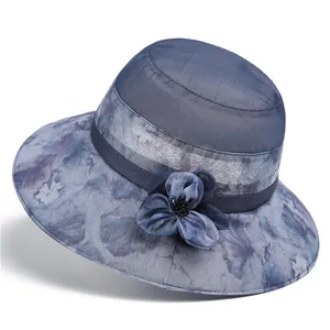 Close-up of mesh sun hat with tie-dye floral pattern and 3D fabric flower detail