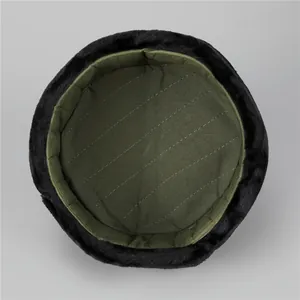 Detail of winter trapper hat with green quilted lining and black faux fur trim