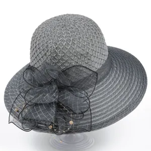 Detail of grey mesh sun hat with a large plaid veil bow and elegant pearl accents