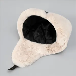 Detail of beige faux fur aviator hat with quilted lining and chin strap buckles