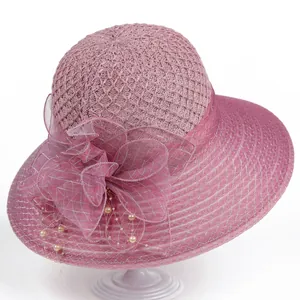 Detailed texture of rose pink sun hat with organza floral accent and pearl charm decoration