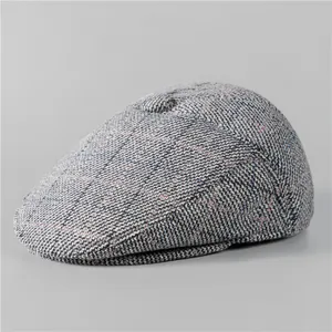 Close-up of grey tweed texture and colorful stitching on elderly men winter flat cap