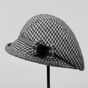 Détail de la casquette octogonale en laine à carreaux noir et gris avec pompon peluche