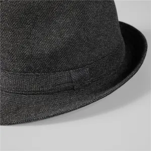 Detailed close-up of dark grey wool fedora hat showing textured fabric and refined stitching
