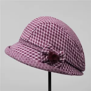 Détail d'un chapeau cloche en laine pied-de-poule violet avec nœud et pompon