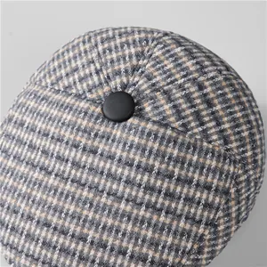 Close-up of vintage plaid winter hat fabric with detailed stitching and top button