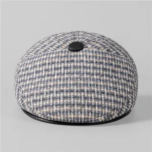 Detailed close-up of grey plaid flat cap with fleece lining and leather trim for men