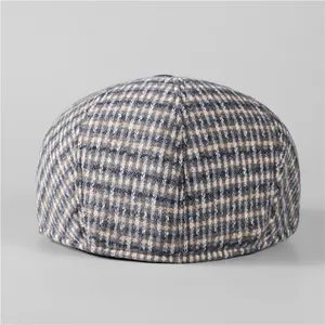 Detail of classic British plaid newsboy cap with wool-like texture and warm lining