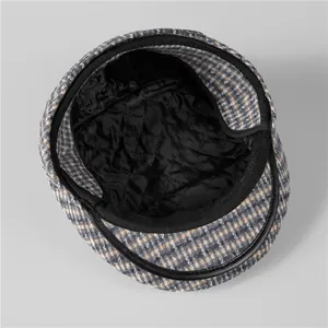 Detailed view of the plaid winter hat featuring warm quilted lining and leather trim