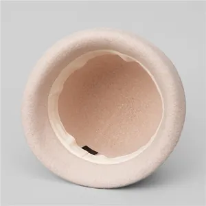 Detail view of pink wool cloche hat interior showing sweatband and stitching