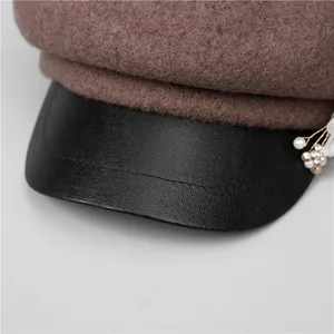 Brown wool newsboy hat with black leather brim and elegant pearl flower decoration