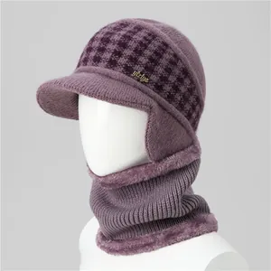 Close-up of purple knit hat set with ear flaps, gold metal tag and thick faux fur lining