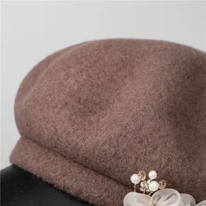 Close-up of brown wool beret with elegant pearl, rhinestone, and mesh flower details