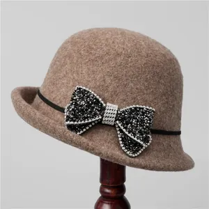 Detail of wool felt cloche hat with rhinestone bow on a wooden stand