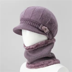 Dettaglio del cappello invernale viola con fiore e scaldacollo foderato in peluche