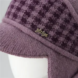 Detail of purple knitted hat for elderly women showing thick fleece lining and brand logo