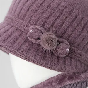Winter knit hat for elderly women in deep purple featuring a plush fur pom-pom and bow