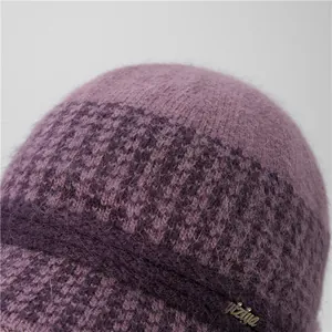 Detalle del gorro de punto de piel de conejo púrpura con textura suave y placa metálica
