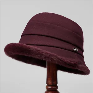 Detail of the wine red wool bucket hat with plush faux fur trim and metal logo accent